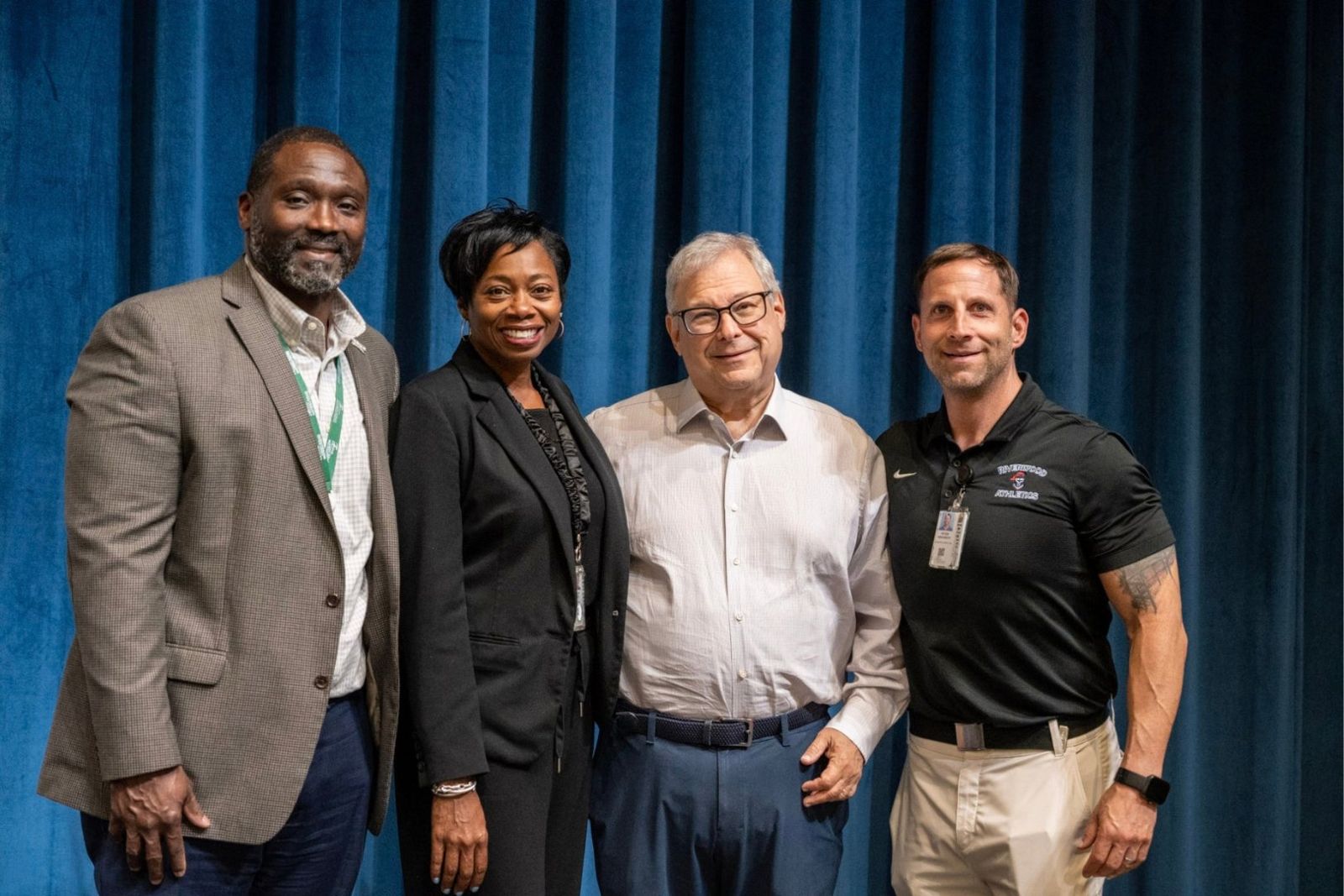 Lamarr Glenn, Principal Kindra Smith, Steve Koonin and Coach P.J. Graybeck on the Riverwood stage