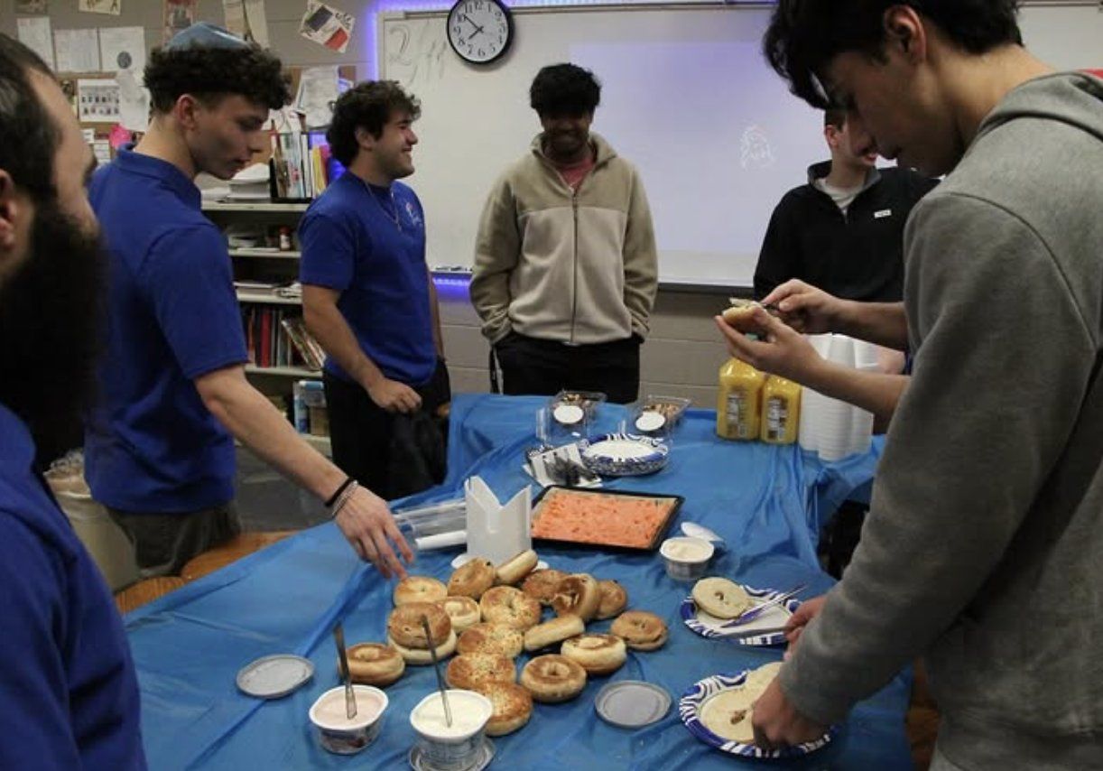Members serving bagels and smoked salmon at a club meeting